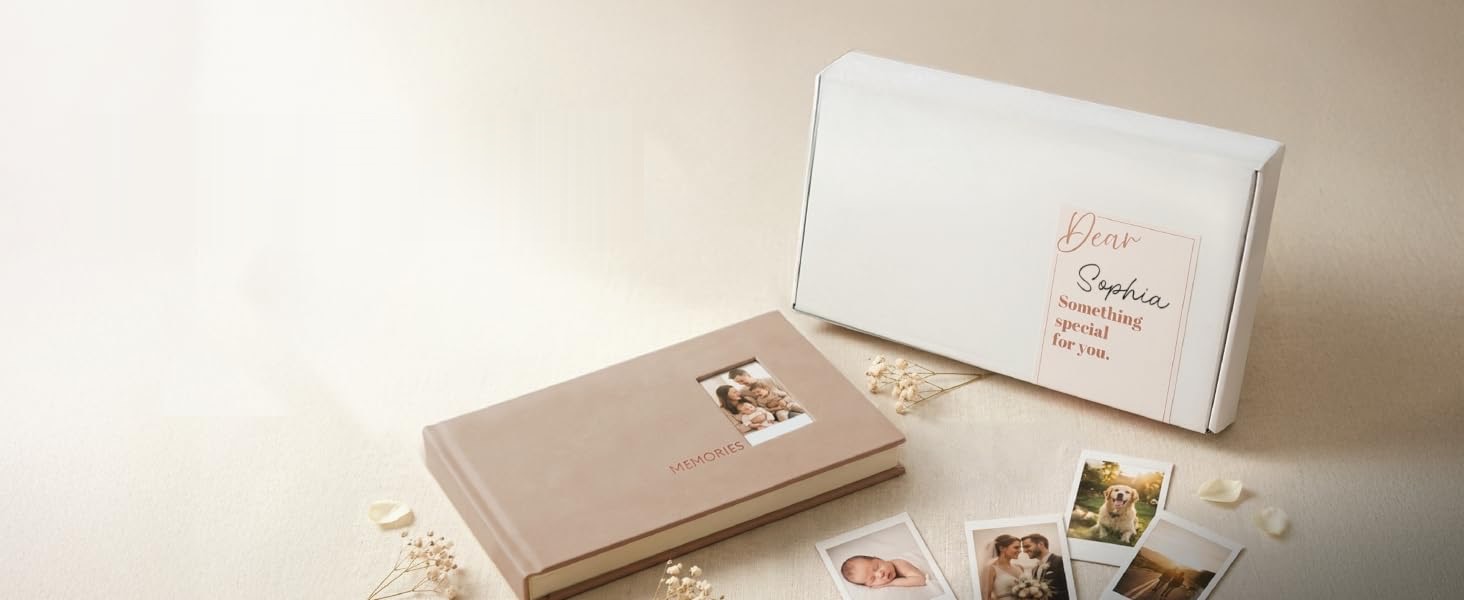 Beige instant photo album with a photo window beside a gift box and Instax Mini photos on a cream table
